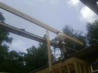Carpenter setting a ridge beam over a new addition frame — Ice Dam Removal by Roofing Brothers in Molino