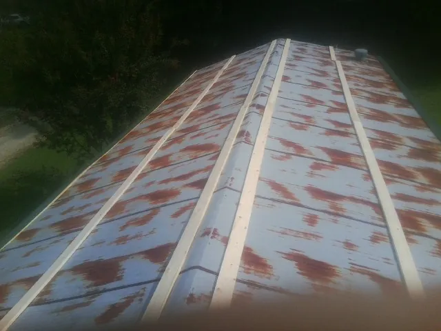 Rusted metal roof panels with new wood purlins before replacement — Storm Damage Roof Repair in Molino by Roofing Brothers