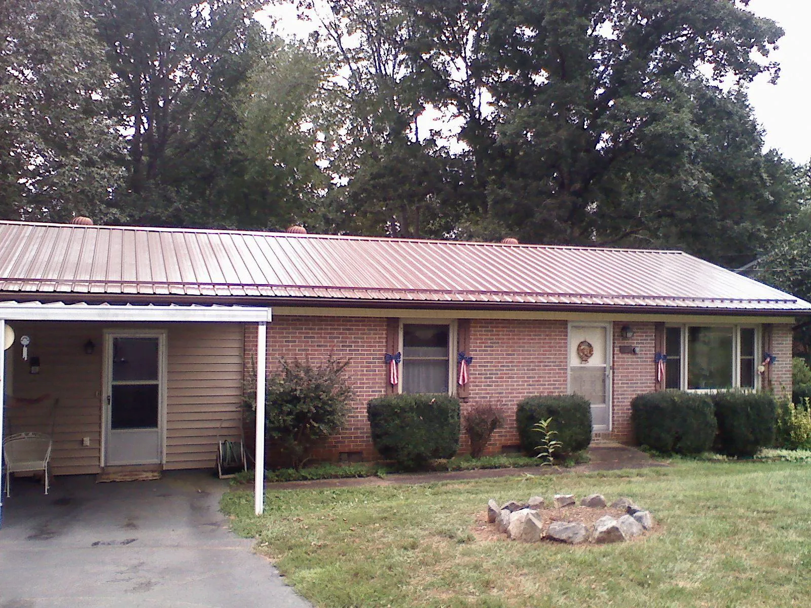 Bronze metal roof and carport on a brick ranch home — Roof Repair work by our crew in Molino